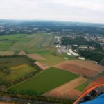 Blick aus dem Tragschrauber über Felder und eine Ortschaft