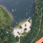 Luftaufnahme eines Ville-Sees mit Badestrand und Wasserskianlage