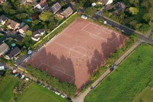Luftaufnahme eines Sportplatzes zwischen Wohnhäusern