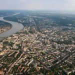 Luftaufnahme des Rheins mit Blick über die angrenzende Stadt