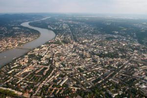 Luftaufnahme des Rheins mit Blick über die angrenzende Stadt