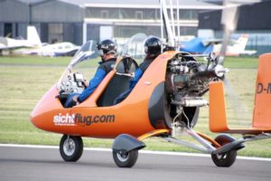 Der Tragschrauber mit Pilot und Passagier auf dem Rollfeld