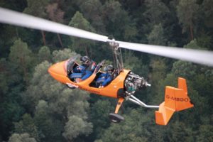 Der Tragschrauber im Flug über den Wäldern der Ville