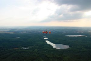 Luftaufnahme eines Ville-Sees und der umliegenden Wälder aus dem Tragschrauber