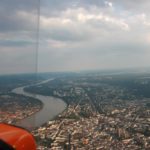 Luftaufnahme des Rheins mit angrenzender Stadtbebauung aus dem Tragschrauber